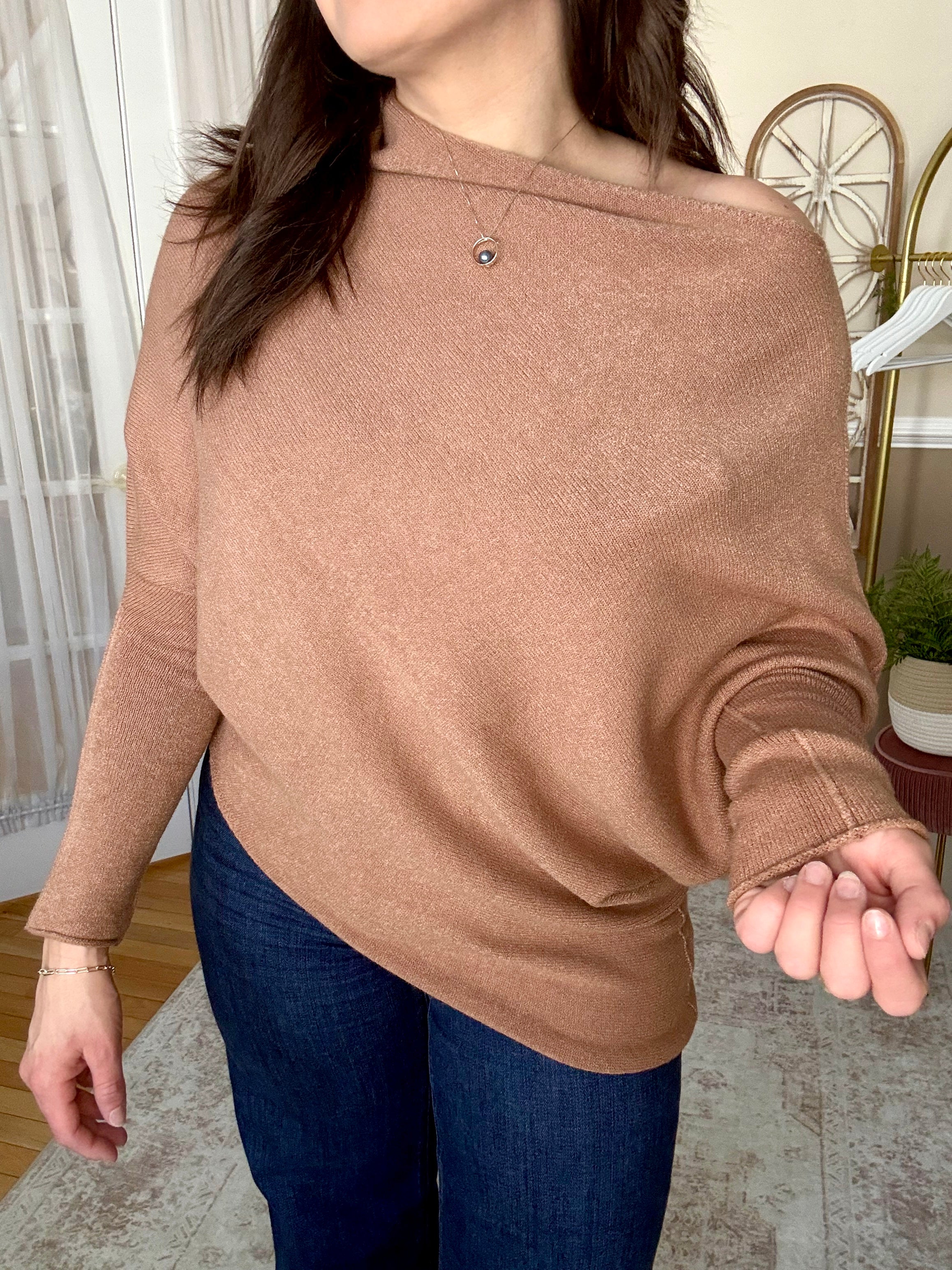 Woman wearing soft wool blend camel assymetrical off the shoulder sweater that is made in Italy