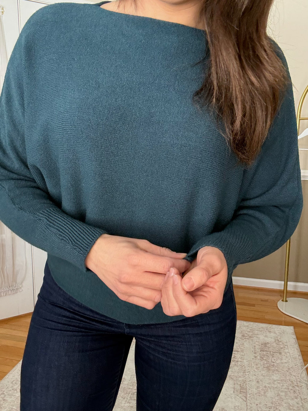 Woman wearing soft wool blend teal boatneck sweater that is made in Italy 