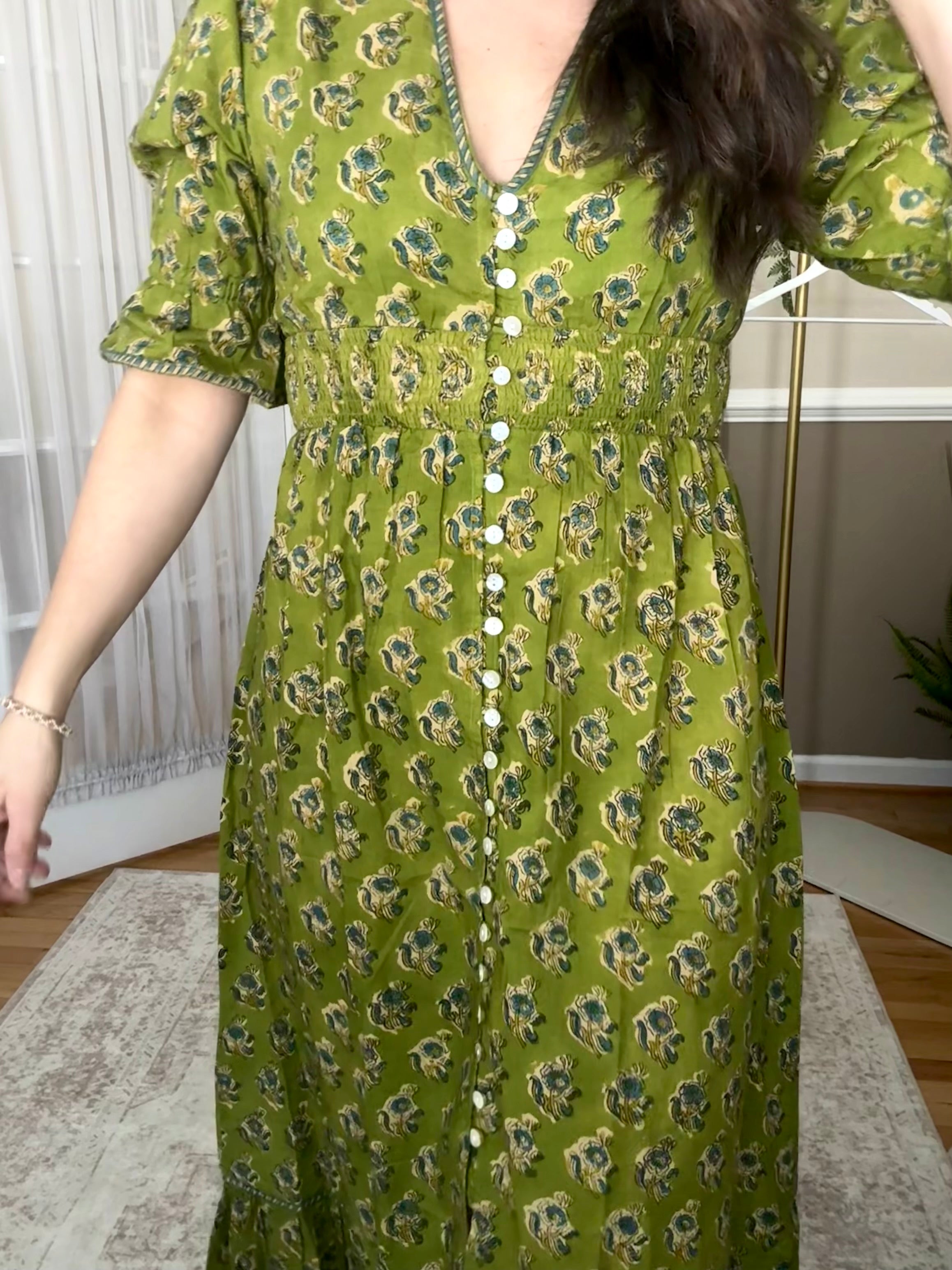 Woman is wearing a green 100% cotton block printed dress that is Made in India 