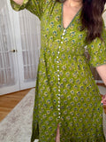 Woman is wearing a green 100% cotton block printed dress that is Made in India 