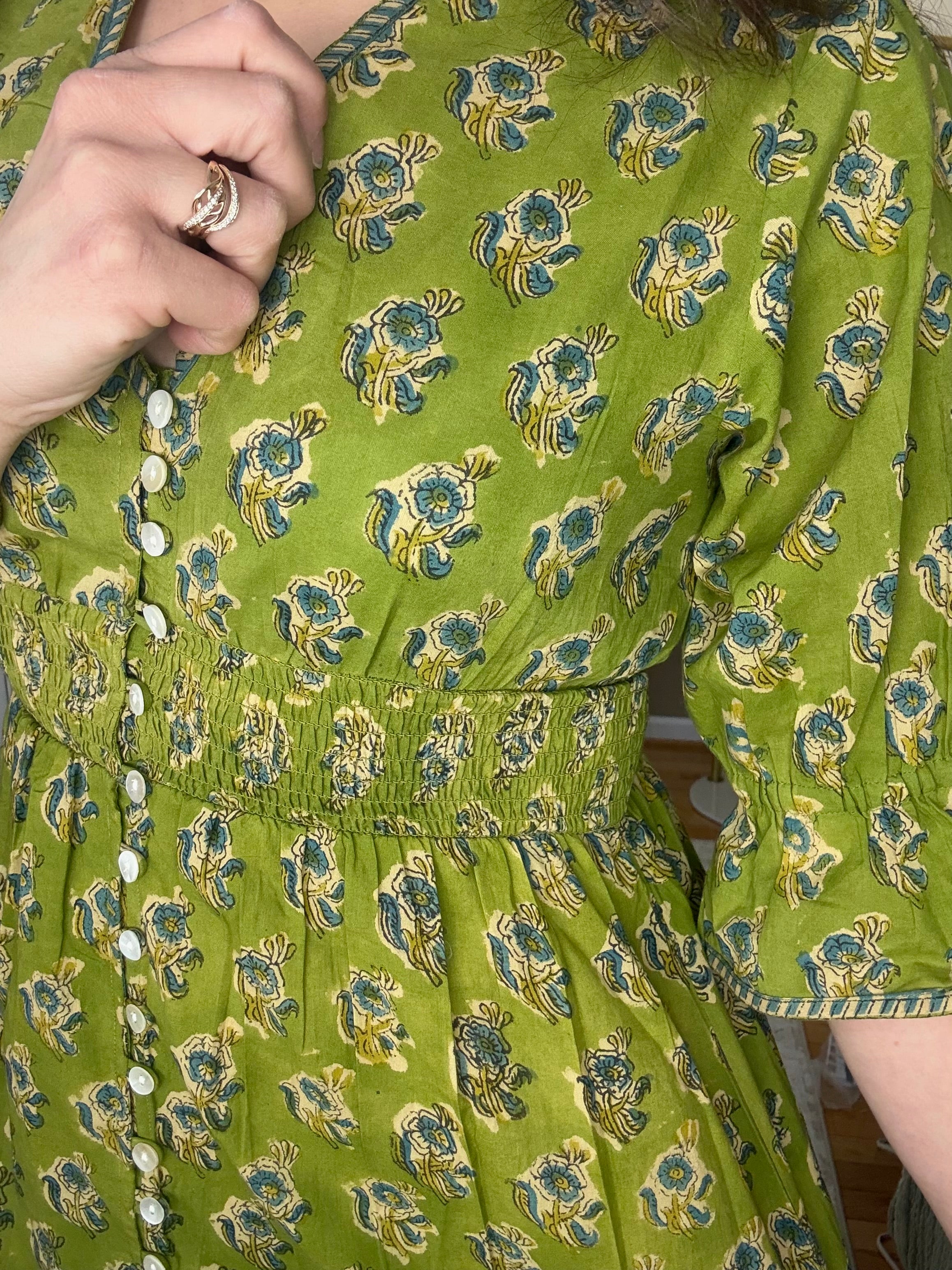 Woman is wearing a green 100% cotton block printed dress that is Made in India 