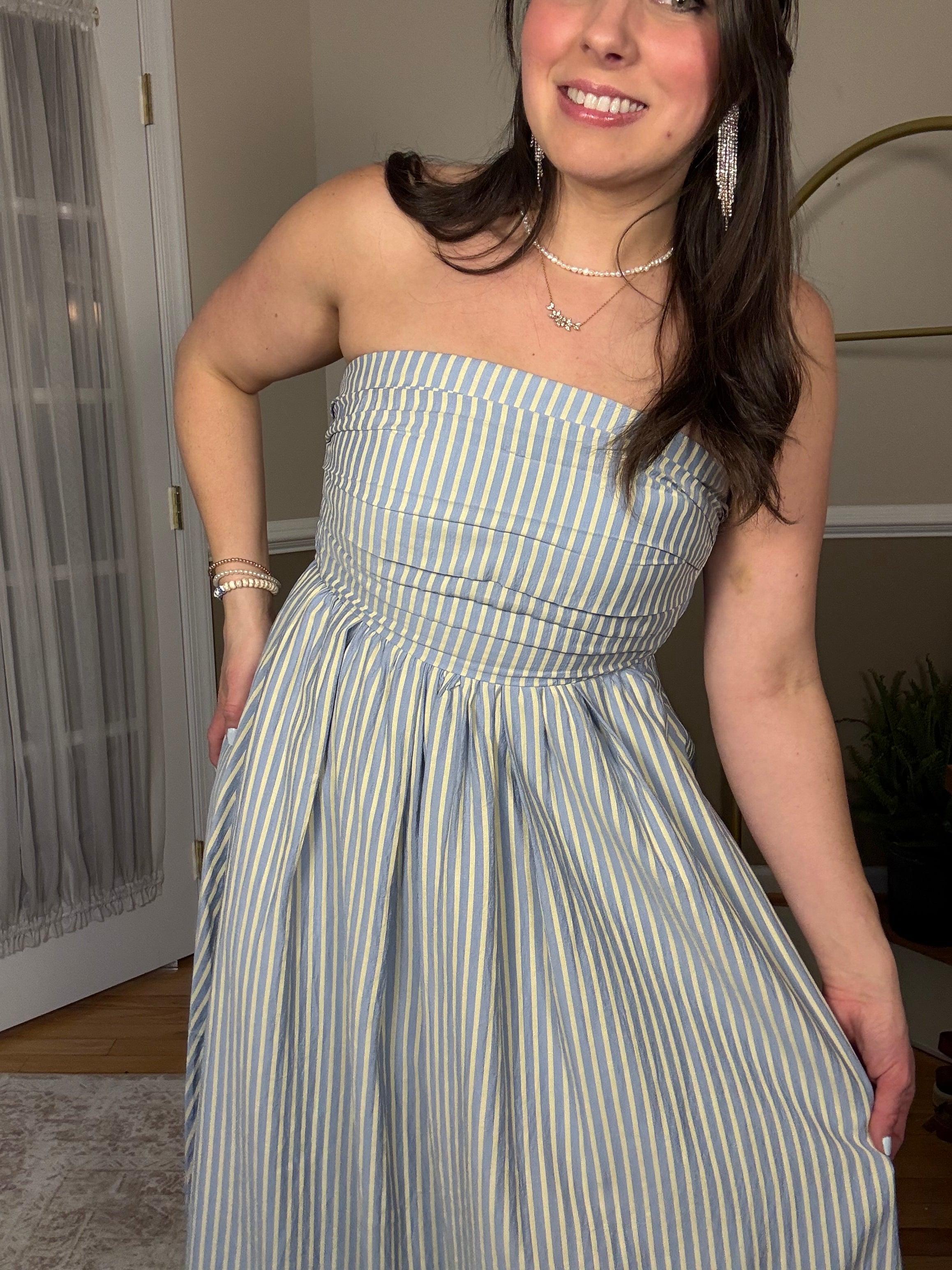 Model wearing a strapless blue and yellow flowy dress, perfect spring and summer dress